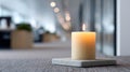 A lit candle on a gray stone coaster in an setting with out of focus lights and behind it Royalty Free Stock Photo
