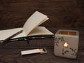 Candle, matches and notebook on a wooden table