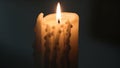 A lit candle with melted wax drips down the sides creating a textured pattern Royalty Free Stock Photo