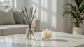 Lit Candle and Reed Diffuser on Sunlit Marble Table in Minimalist Living Room Royalty Free Stock Photo