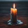 A lit candle stands on a surface with melted wax pooled around its base Royalty Free Stock Photo