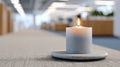A lit candle on a table in an setting with blurred background elements Royalty Free Stock Photo
