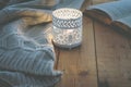 Lit Candle White Knitted Sweater Open Book on Plank Wood Table by Window. Cozy Winter Autumn Evening. Natural Light Royalty Free Stock Photo