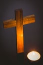 Lit candle by wooden cross Royalty Free Stock Photo