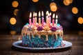 Lit candles adorn a colorful birthday cake on a wooden table