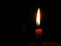 Burning candle in right position and dark background, copyspace. Royalty Free Stock Photo