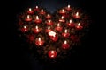 lit candles forming a heart shape in darkness Royalty Free Stock Photo