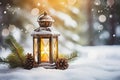 Lit Christmas lantern under the Christmas tree in the snow, covered with snow at night outdoors. Christmas mood. Selective focus.