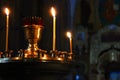 Lit church candles in a gilded candlestick in a temple in the dark. yellow wax lighted candles stand in the church, glow Royalty Free Stock Photo