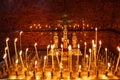 Lit church candles in a gilded candlestick in a temple in the dark. yellow wax lighted candles stand in the church, glow Royalty Free Stock Photo