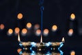 Lit diyas on table against blurred lights. Diwali lamps