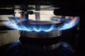 A lit gas burner burns with a blue flame on a kitchen stove Royalty Free Stock Photo