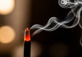 A lit incense stick burns, emitting a soft, glowing tip with visible Royalty Free Stock Photo