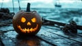 Lit Jack-o\'-Lantern on a Wooden Deck with a Blurry Ocean Background Royalty Free Stock Photo
