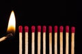 Lit match next to a row of unlit matches. Royalty Free Stock Photo