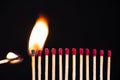Lit match next to a row of unlit matches. The Passion of One Ignites New Ideas, Change in Others. Royalty Free Stock Photo
