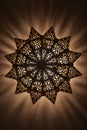 Lit, Moroccan, Arabian lamp with intricate decor. Bottom view.