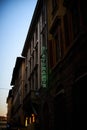 a lit sign stands in the middle of a street corner