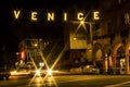 Lit street sign over cars` starburst lights mark entrance to Venice Beach, California Royalty Free Stock Photo