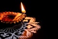 A lit terracotta lamp or clay diya placed on black background. festival of lights or deepawali concept Royalty Free Stock Photo