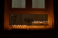 Lit and unlit Hanukkah menorahs in a window Royalty Free Stock Photo