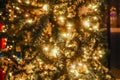 Lit up Christmas tree outside on street with bokeh circle lights on tree and in distance - blurred Royalty Free Stock Photo