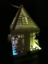 Lit Up Holiday Laser Cut Paper House Decoration with a Christmas Tree and Colorful Joyful Lights Glowing in the Dark