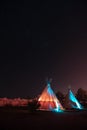 Lit up teepees at night under a sky of stars in Marfa, Texas