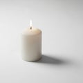 White cylindrical candle positioned upright on a smooth white Royalty Free Stock Photo