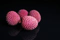 Litchi chinensis. Exotix litchi fruit fruits on black reflective studio background. black shiny mirror mirrored backgroun Royalty Free Stock Photo