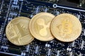 Litecoin, Ripple & Bitcoin golden coins representing cryptocurrenies