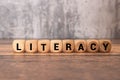 Literacy word in wooden cube blocks, reading and writing concept Royalty Free Stock Photo