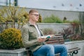 Literary Urbanite A Young with eyeglasses Man Sitting with Book in the City