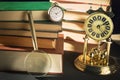 Literature concept. Magnifying glass near vintage clocks and old books against black background. Royalty Free Stock Photo