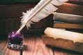 Literature concept. Old inkstand with feather near scroll and books Royalty Free Stock Photo