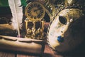 Literature concept. Still life with feather in inkstand, scroll, venetian mask, old books,vintage clock and box on wooden table. V