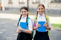 After literature lesson. prepare to exam. study together outdoor. girls with books and backpacks. children hold notebook Royalty Free Stock Photo