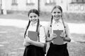 after literature lesson. prepare to exam. study together outdoor. girls with books and backpacks. children hold notebook Royalty Free Stock Photo