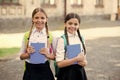 after literature lesson. prepare to exam. study together outdoor. girls with books and backpacks. children hold notebook Royalty Free Stock Photo