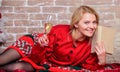 Literature lover. Girl in red dress relaxing with glass of champagne near christmas tree. Reading bucket list. Happy Royalty Free Stock Photo