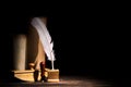 Literature and poetry concept. Old inkstand with feather quill, blotter, seal near scrolls against black background. Dramatic