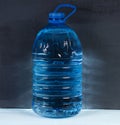 5 liters. Big plastic bottle of potable water on a dark background. Royalty Free Stock Photo