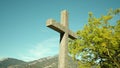 Lithic cross monument against mountains and trees in park