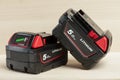 Lithium battery for cordless drill. Screwdriver battery. Four batteries with a charge indicator lie on a wooden Royalty Free Stock Photo