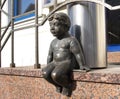 Lithuania, Klaipeda. Sculpture of the boy sitting on a porch of the building