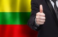 Lithuanian concept. Businessman showing thumb up on the background of flag of Lithuania