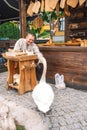 Lithuanian craftsman in traditional costumes carving wood and selling his handmade wooden artifacts