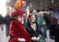 Litle girls with carnival masks parade through the street of the noble palaces of Genoa