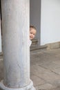 Litlle child peeking behind ancient column