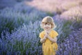 Litlle girl on lavander field in yellow dress smiing